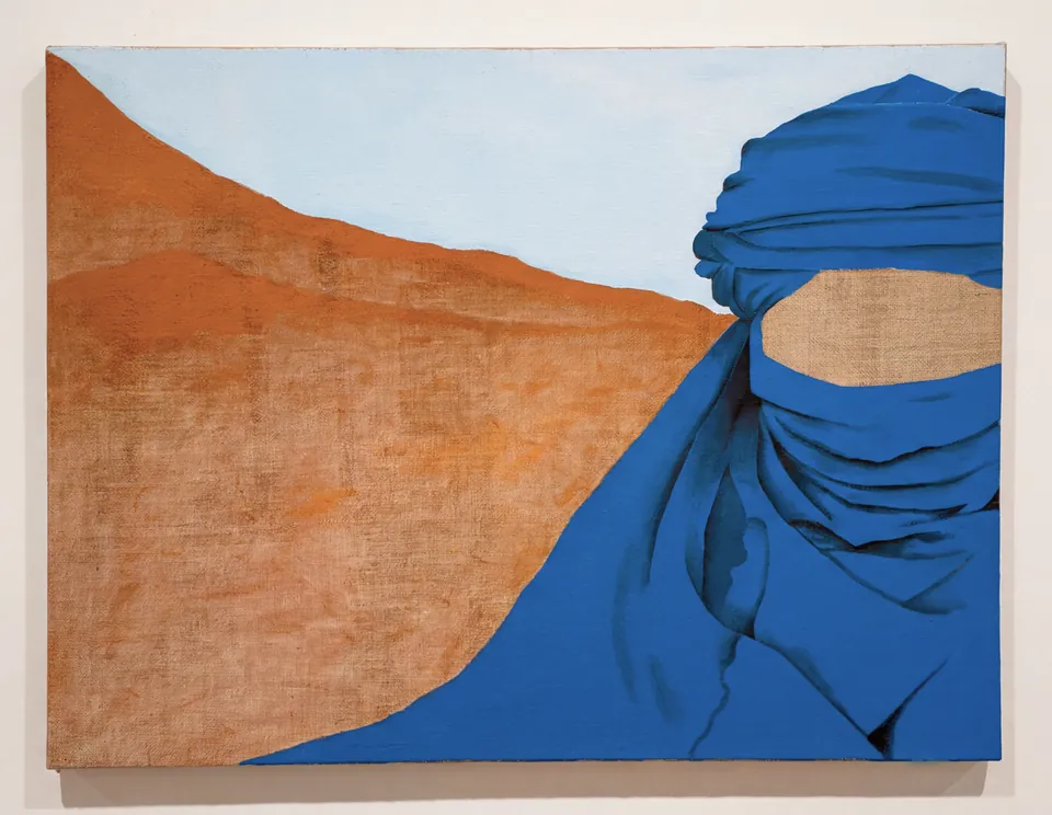 Peinture : des dunes orangées sous un ciel pâle ; à droite, une figure drapée d’un voile bleu dont le visage est laissé en toile brute.